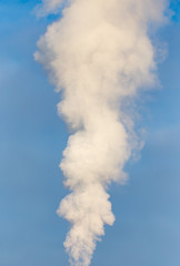 smoke from a pipe in the factory against a blue sky