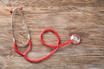 Stethoscope on wooden background. Health care concept