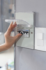 Woman hand  turning off fuse box in the house