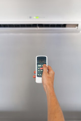Fototapeta premium Hand using a remote control to activating air conditioning