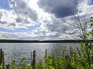 Summer landscape: blue lake on a Sunny day and sky with feathery clouds