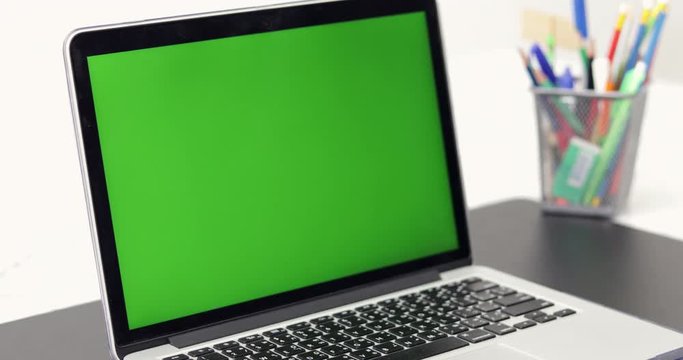 4K : A laptop computer with a key green screen set on work office table.