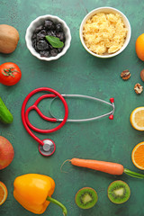 Fototapeta na wymiar Healthy food with stethoscope on color background