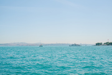 Obraz premium A ship or a passenger liner sails along the Bosphorus in Istanbul. Urban architecture in the background