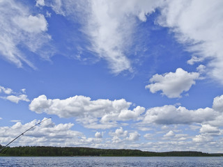 Obraz premium Summer landscape: blue lake on a Sunny day and sky with feathery clouds