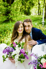 A charming couple poses in a park with scenery