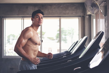 Obraz premium Fitness man running on treadmill in gym