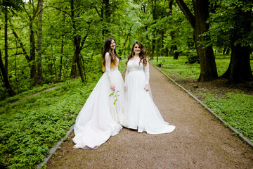 Two sweet brides are standing in the park