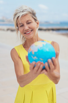 Happy blond woman holding a world globe