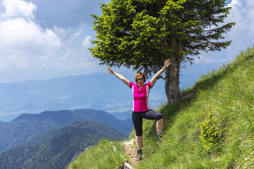 Active woman hiking in the mountains above the valley