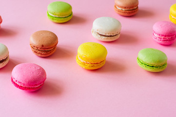 Colorful macarons- french cookies on a pink background. Top view