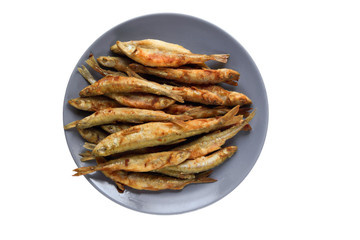  fried smelt on a plate on a light background