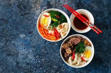 Two variation  udon noodles bowls. with broccoli, ed, carrot, sp