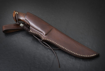 Hunting knife handmade on a black background. Leather Sheath Handmade