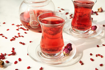 Glass cups of aromatic tea on light background