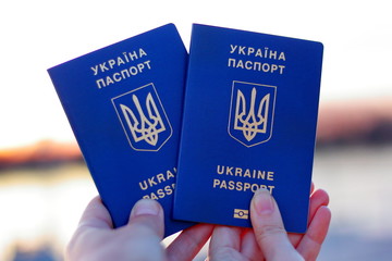 Two Ukrainian biometric passports in hand. Concept of traveling and resting together