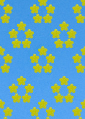 Abstract summer flower made of yellow candy on a blue background. Template.