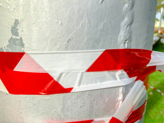 Red white tape to prohibit twisting the stab in the street. Close up shot