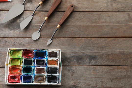 Tools and paints of professional artist on wooden table