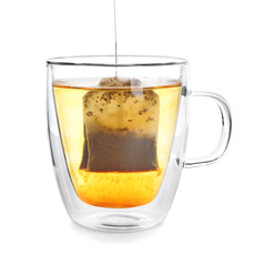 Brewing of hot beverage with tea bag in glass cup on white background