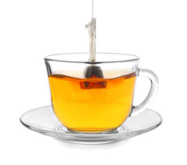 Brewing of hot beverage with tea bag in glass cup on white background