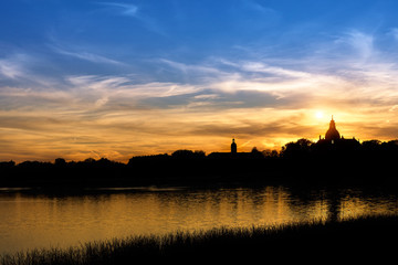 Fototapeta na wymiar silhouette of the castle near the lake on sunset background