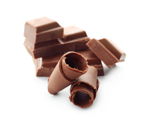 Pieces of chocolate with curls on white background
