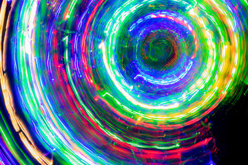 The round of blurred lines of color lights on dark background. Colorful lights blurred by motion.