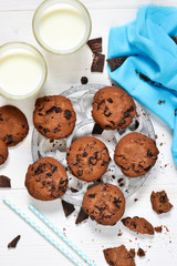 Homemade chocolate chip cookies on a white background with milk.