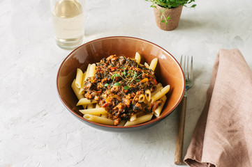Tomato sauce ground beef pasta on a white stone background. Tone