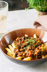 Tomato sauce ground beef pasta on a white stone background. Tone