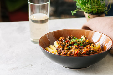 Tomato sauce ground beef pasta on a white stone background. Tone