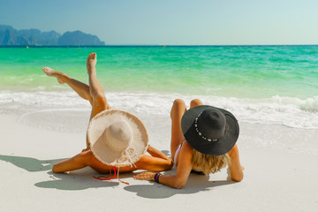 Fototapeta na wymiar women sunbathing lying down on the tropical beach