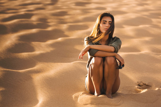 Young girl sitting on a sand dune