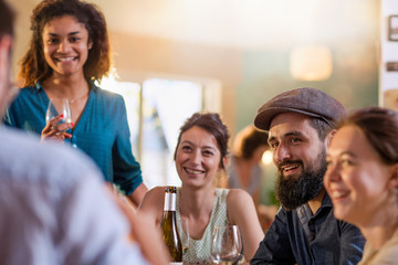 Mixed group of friends having fun while sharing a meal 
