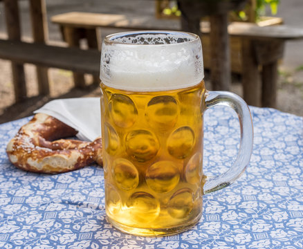 Mug of beer and a soft pretzel on a table