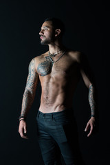 Fototapeta na wymiar Bodycare with fitness and sport. Tattooed man show sexy muscular torso. Sportsman with six pack and ab. Bodybuilder with biceps and triceps. Fashion model with tattoo in jeans