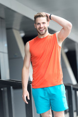 Man with bristle on smiling face in sporty wear, urban background. Sport fashion concept. Man with...