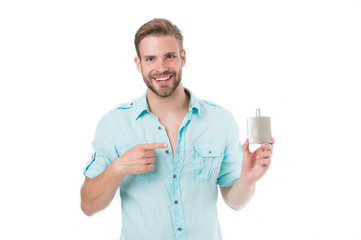 Happy man point finger at perfume bottle. Bearded man smile with deodorant isolated on white background. Presenting product concept. Hygiene and health. Getting fresh