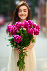 Spring / Summer Style. Beautiful Young Brunette Woman In A Nice Spring Dress With A Bouquet Of Pions. Beautiful Spring Street. Fashion Spring Summer Photo.