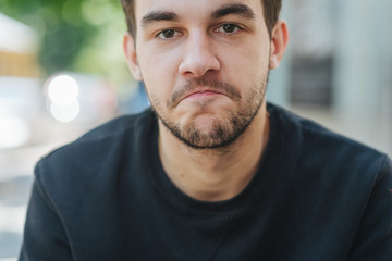 Fototapeta premium A young handsome man was surprised and bit his lip. Live emotions, space for text