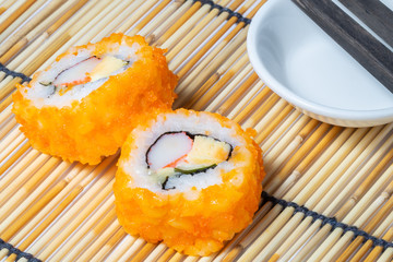 Sushi roll and chopstick on bamboo rolling mat
