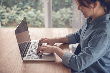 Naklejka premium Smiling woman uaing laptop in home office