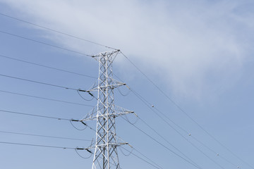 Blue Sky with white clouds and an electric tower with a cable connection