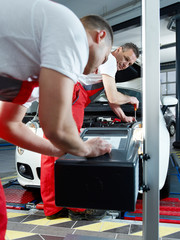 Car mechanic testing light of car in garage