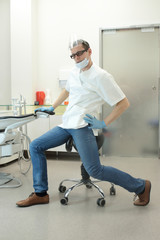 male dentist stretching his legs  in the office during break