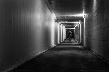 Man walking through a tunnel at night