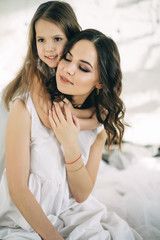 Mother and daughter embracing in the morning at home. Happy family concept...