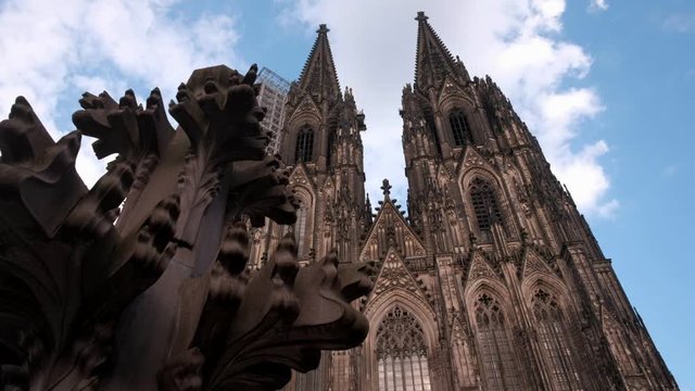 Camera slides past the Kreuzblume sculpture to reveal the facade of Cologne Cathedral 