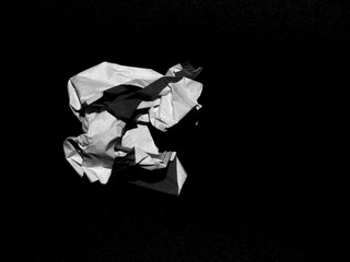 Crumpled paper ball on black background